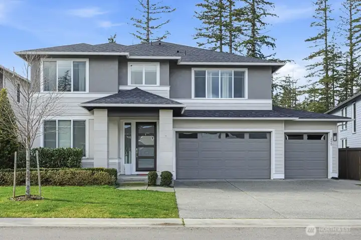 Clean lines and balanced proportions define the façade, where layered textures and crisp trim details create a polished first impression. Manicured landscaping and a three-car garage add both curb appeal and everyday functionality.