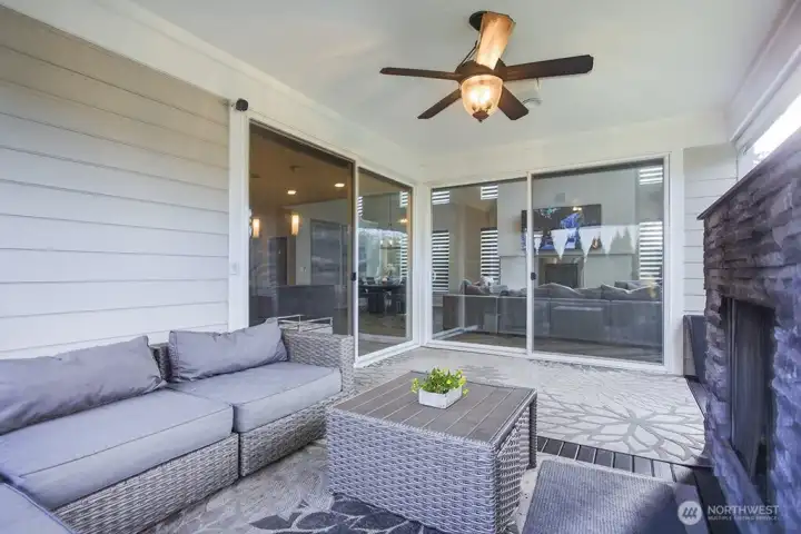 Expansive sliding glass doors seamlessly connect interior and exterior spaces, allowing the covered patio to function as a natural extension of the great room.