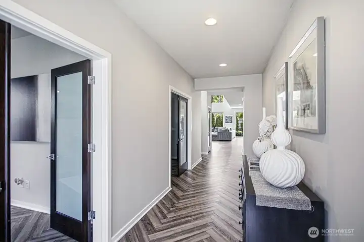 Clean lines and wide-plank herringbone flooring guide you toward the light-filled heart of the home.