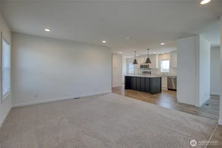 Open concept living room flows into kitchen and dining/flex room.