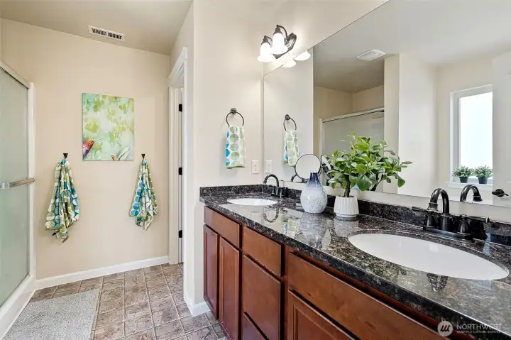 Five-piece en suite with granite slab countertops and double vanity.