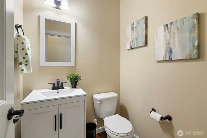Downstairs half bath with slab vanity and under-counter storage.