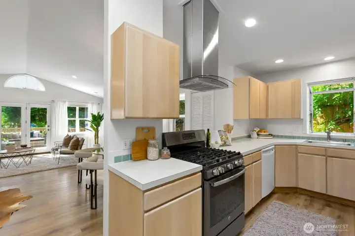 The kitchen has a stainless-steel gas stove and hood vent.