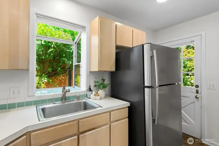 One more view of the kitchen showing the fridge and the Dutch door that leads out to the backyard.