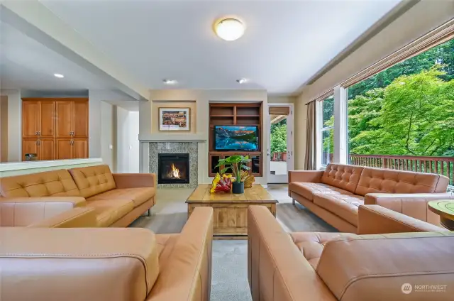The family room has a gas fireplace and media built-in with a door leading to the deck.
