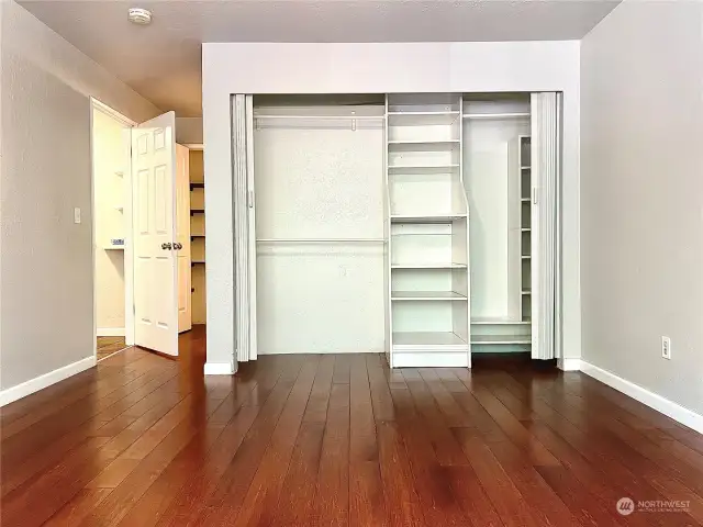 Closet organizers in the primary bedroom. Pictured to the left, behind the door is a linen closet for more storage space. The primary bathroom is also back there.