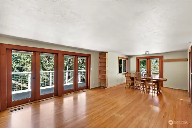 Spacious, open living/dining room, with French doors to two decks. Hardwood floors were under carpet for years.