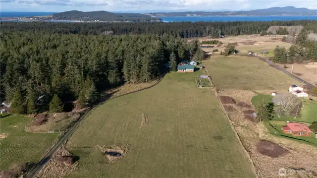 Sunny, idyllic, island farmstead with a main residence, guesthouse, barn, outbuildings, fenced garden, greenhouse, chicken coop with covered run, and more on ten pristine acres of field and forest overlooking a lovely valley on Lopez Island
