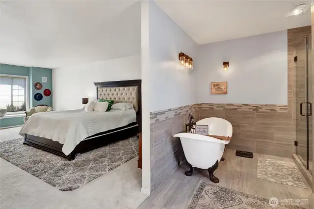 Primary bedroom with primary bathroom pictured, and clawfoot soaking tub.