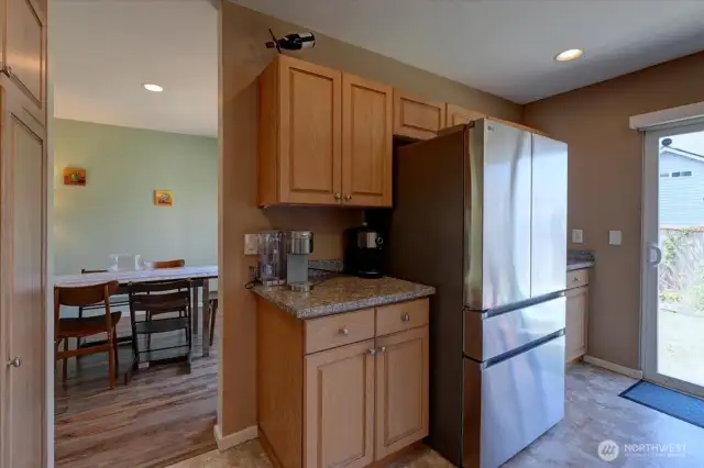 Newer fridge flanked by cabinets and countertops.
