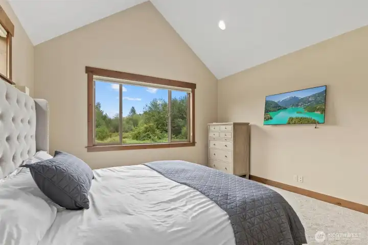 Primaray Bedroom With Vaulted Ceilings and Large Picture Framed Window
