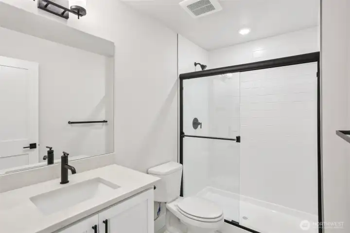 Lower level ensuite bath highlights upgraded matte black finishes found throughout the home.