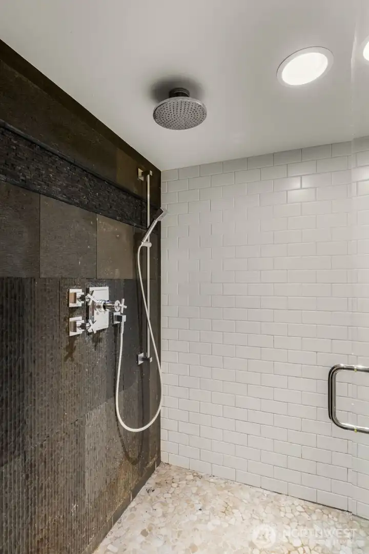 three quarter bath connected to the laundry room offers a massive shower with rain shower head for a deluxe bathing experience