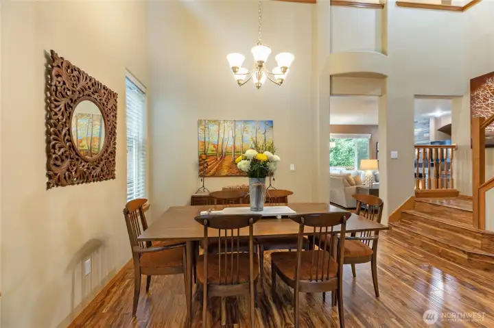 Host dinner parties in this sun-drenched dining area. The open-concept layout and high ceilings provide an airy atmosphere, while the proximity to the grand staircase adds a touch of architectural drama.