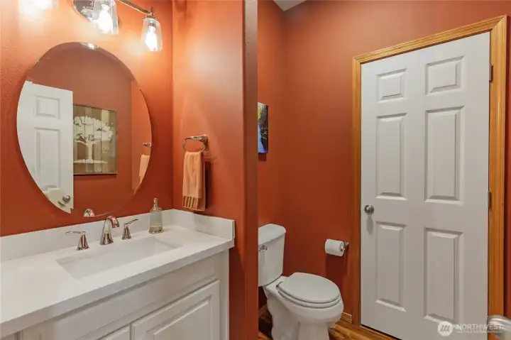 The stylish main-level half bath features a modern vanity and elegant fixtures. Notably, the oversized layout provides ample room to easily add a shower, offering the potential to convert this into a second full suite on the main floor.