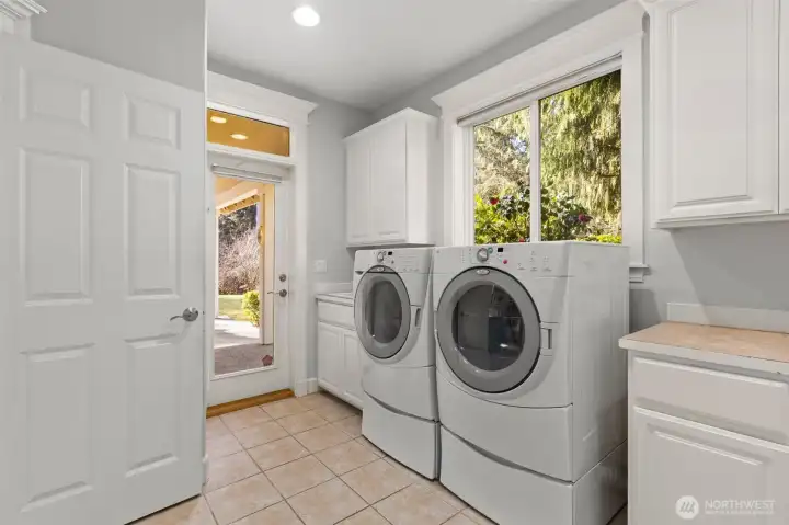 Spacious laundry room with a sink and ample counterspace and storage.