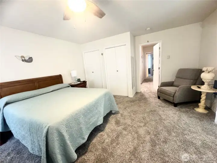 Primary bedroom features two closets and room for a reading area. This spacious room offers comfort and functionality, with ample space for relaxation and storage.