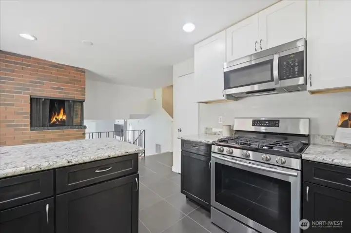 Tastefully renovated kitchen with stainless steel appliances, gas oven and range, and marble slab counter tops.