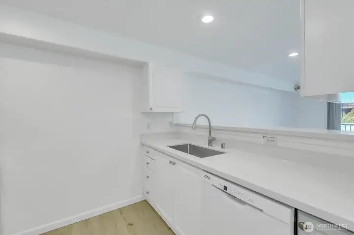 New quartz countertops, undermount sink, faucet & garbage disposal. Dishwasher newer as well. Lots of room for storage shelves on back wall.