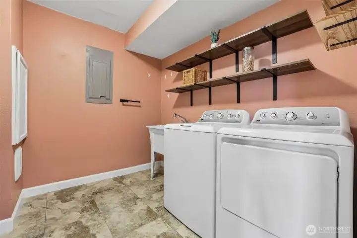 large laundry room with storage and laundry chute