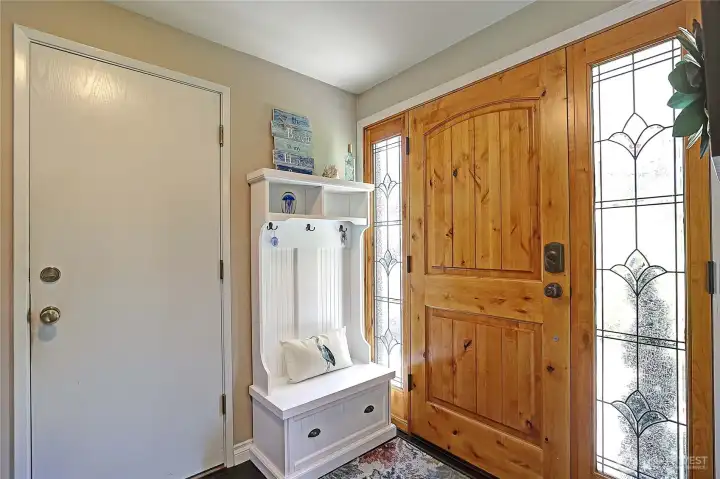 Warm and inviting entry with beautiful natural wood front door.