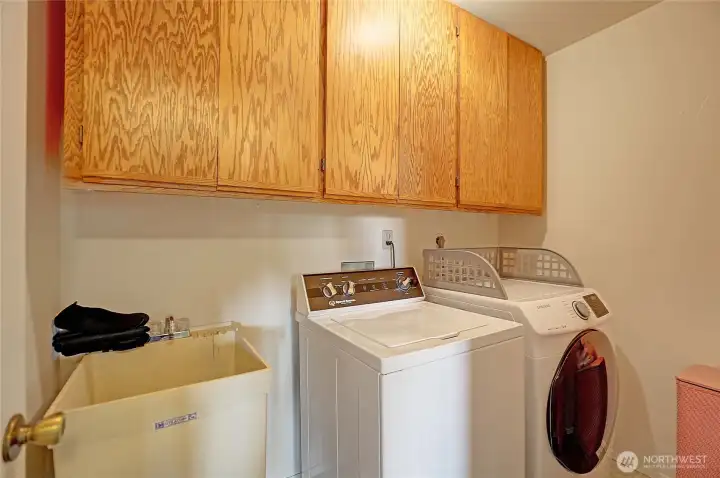 Dedicated laundry area with built-in upper storage.