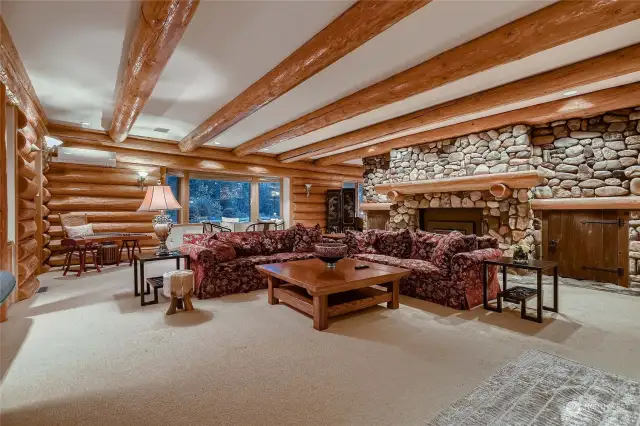 Great room with beamed ceiling and river rock fireplace.