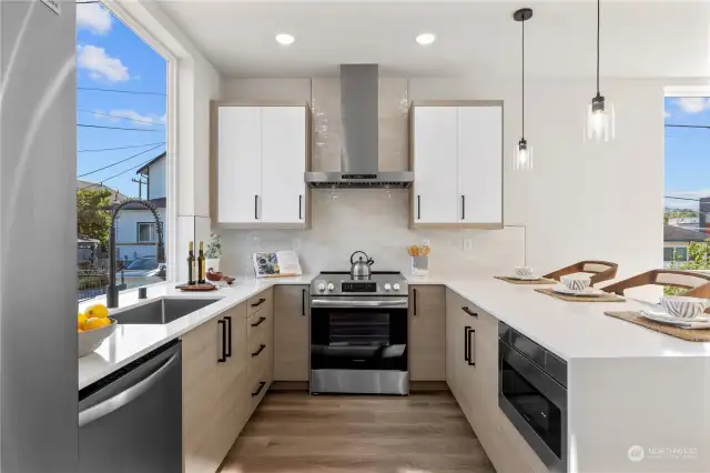 This modern kitchen boasts sleek cabinetry, stainless steel appliances, quartz countertops, and an expansive countertop perfect for entertaining