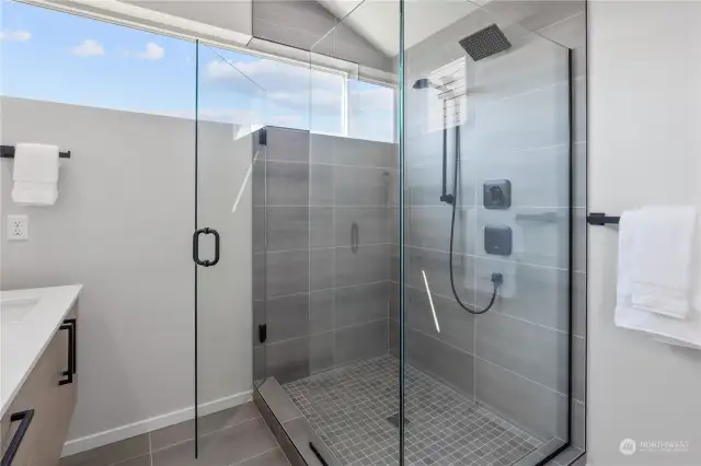 A luxurious walk-in shower with modern tiles and high-end fixtures, perfect for relaxation.