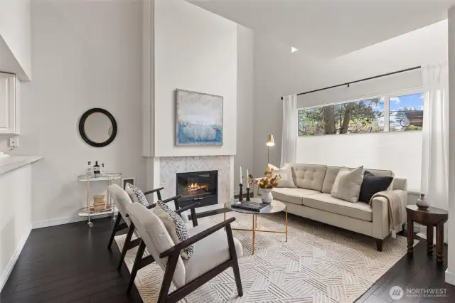 Spacious living rm with gas fireplace, custom window treatments & motorized blinds on upper windows.