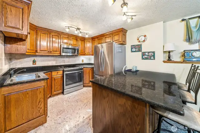 Lower-level kitchen has never been used.  Granite countertops, new appliances, breakfast bar, oak cabinetry.