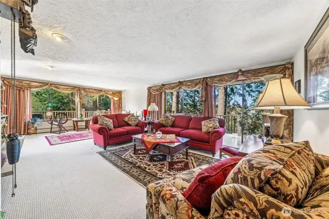 Living room with slider to deck, fireplace with wood stove insert.