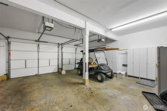 Two car garage with storage, washer and dryer. Golf cart is available for sale.