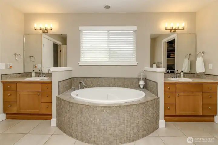 double vanities flank either side of the huge soaking tub in the primary bathroom