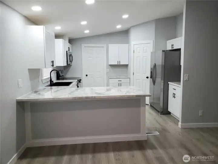 Very Spacious All New Kitchen with New White Cabinets, Counter Tops with Breakfast Eating Bar Walk In Pantry, Stainless Appliances Including Microwave, New Paint, Sink, Faucet, Recessed LED Lighting, Trim and Vinyl Plank Flooring.