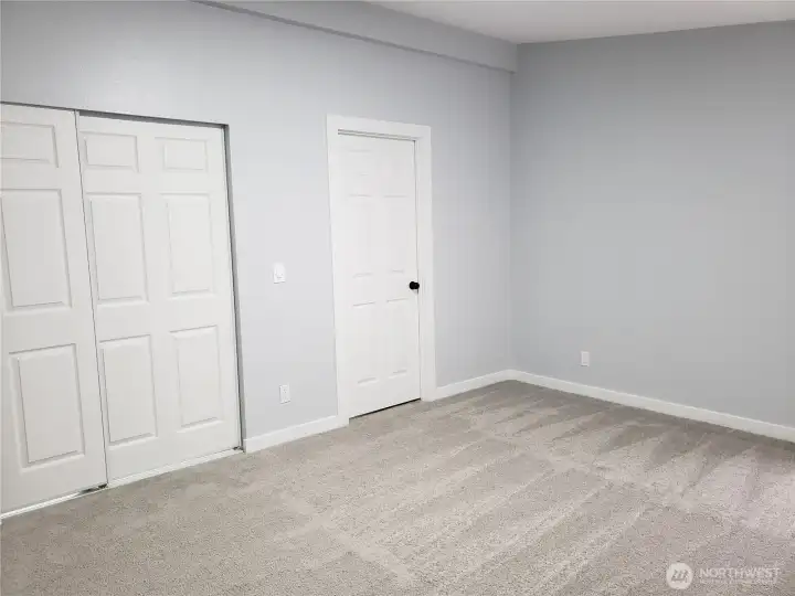 A Different View of the Primary Master Bedroom Showing Cathedral Ceilings, All New Paint, Trim and Carpeting Looking at the Walk In Closet and Primary Master Bath Room.