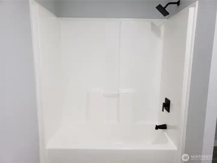 Another View of the Primary Master Bath Room Showing  New Shower Tub Combination, Paint, Trim and Vinyl Plank Flooring.