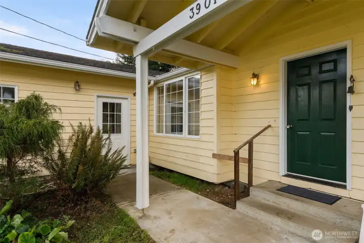Covered front porch providing sheltered entry, everyday outdoor use & side door to the garage