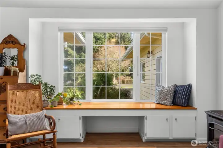 Built-in window seat with storage and views to the front yard, adding character and functional seating to the living space.