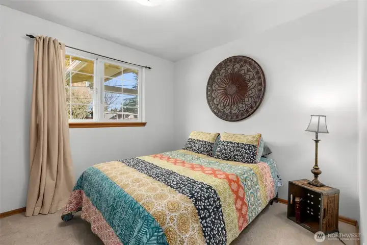 Second bedroom with carpet flooring, window, and closet space.