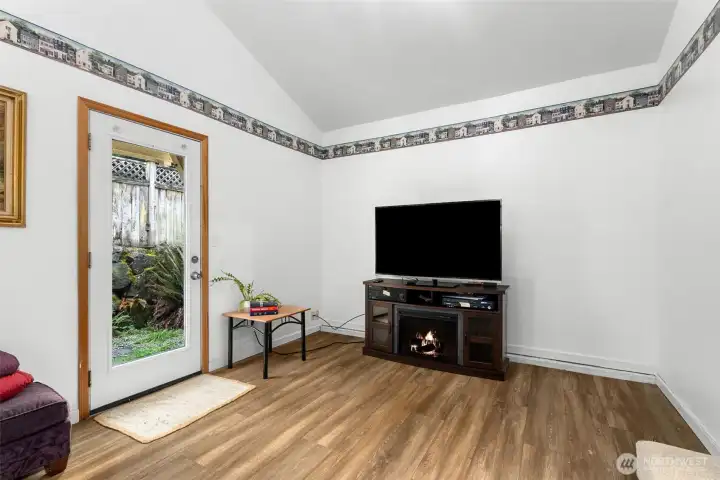 Bonus room featuring durable LVP flooring, exterior access door, and space for media, hobbies, or home office use.