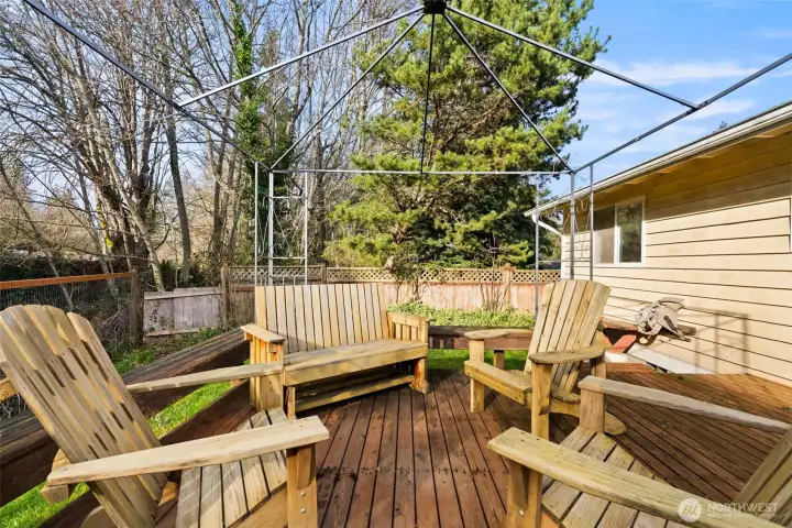 Large deck with built-in seating and open-air structure, providing flexible outdoor living space.