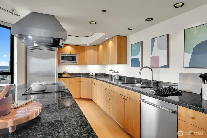 Sleek kitchen features honey colored bamboo floors, and high end appliances.