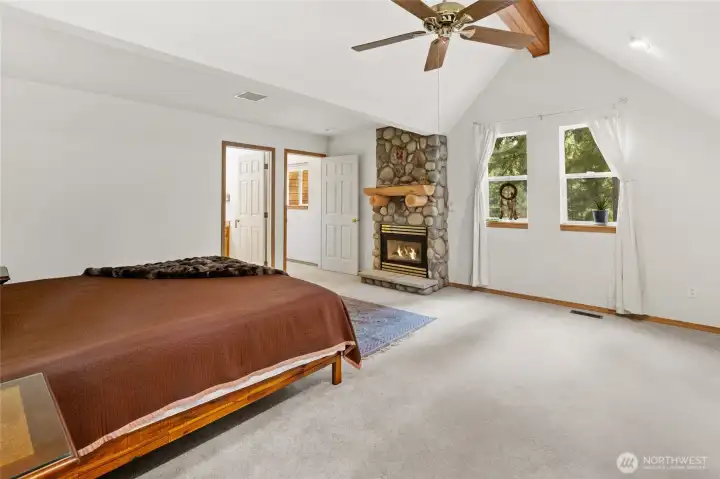 The primary suite is generously sized, with vaulted ceilings and a fireplace that create a relaxing retreat.