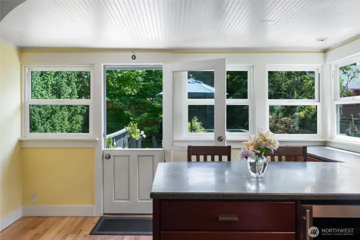 Eating bar with wrap around windows and dutch door leading to spacious deck with built in seating