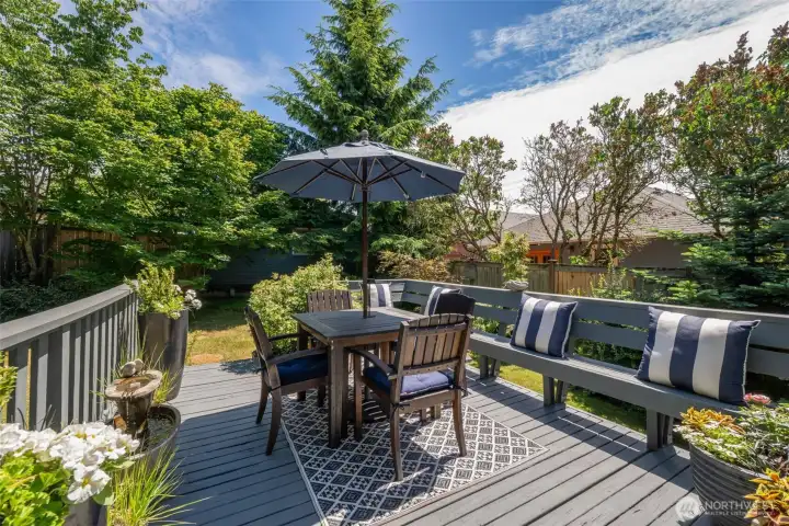 Expansive deck with built-in seating off the kitchen is perfect for your summer gatherings