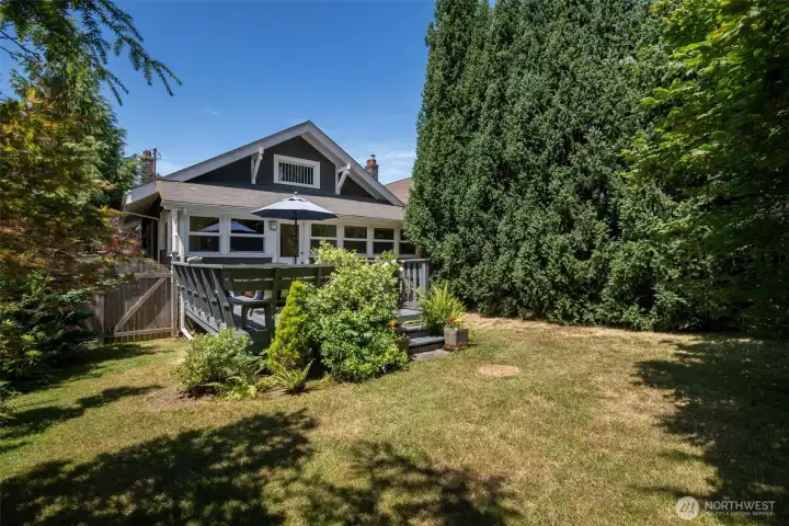 The back yard level backyard with lush  mature landscape provides privacy, shade, and room to roam