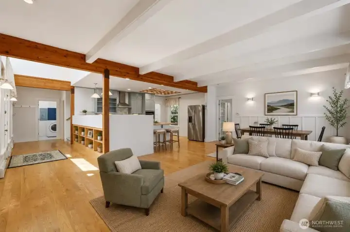 Virtually staged. Light-filled open living area showcasing hardwood floors, charming wood beam accents, and a flexible layout perfect for gathering, entertaining, or everyday living.
