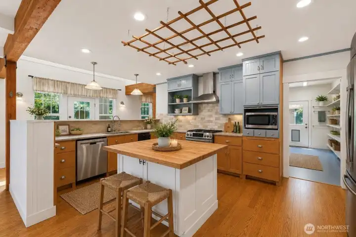 Virtually Staged. Recently updated chef-style kitchen with large island, stainless steel appliances and brand new fridge. Notice the large pantry space to the right side of the kitchen.
