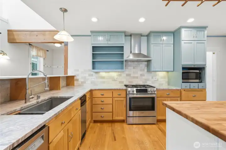 Chef-inspired kitchen with custom cabinetry, gas range, stainless steel appliances, and abundant workspace.